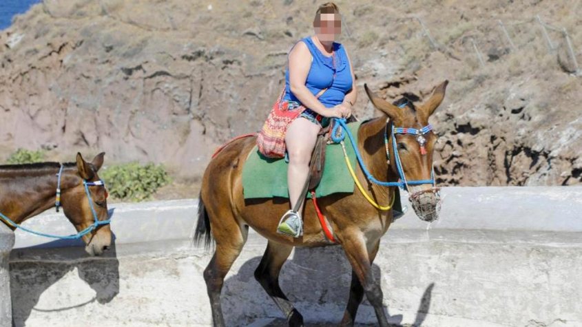 Dicke Touristin auf Esel. in Santorinijpg